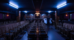 Underground club interior before opening with staff setting up under cold work lights