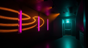 Dark nightclub interior with amber and gold pulsing light patterns on walls, hot pink accent fixtures, teal light near exit