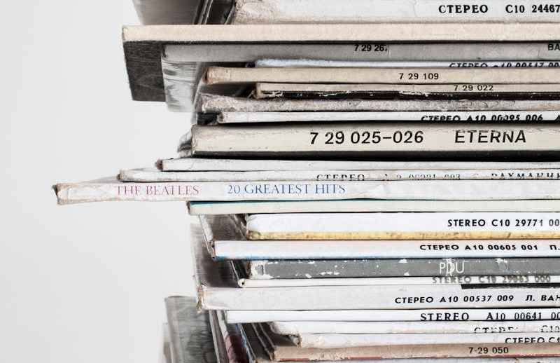 A stack of vinyl records including a Beatles greatest hits LP