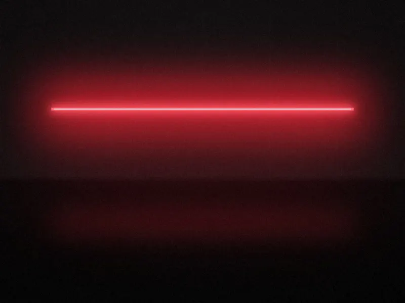 A single line of red light in a dark concrete room