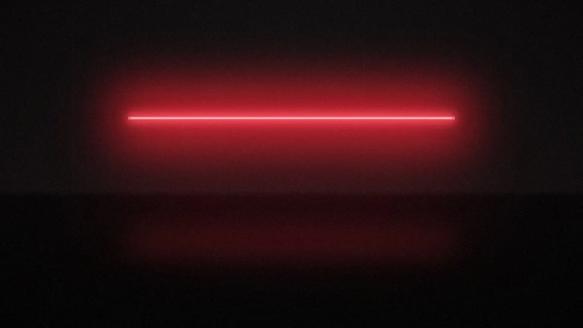 A single line of red light in a dark concrete room
