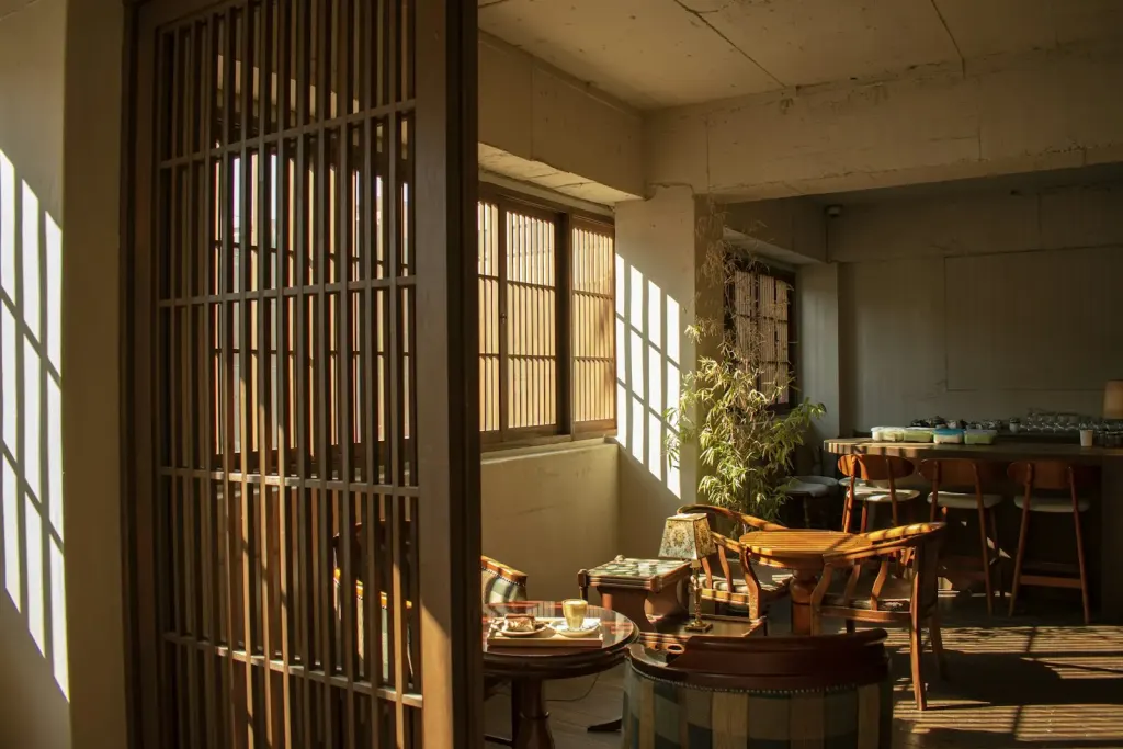 An empty cafe with afternoon light through wooden screens