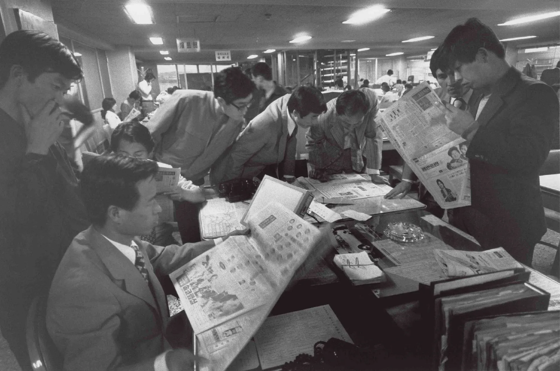 Korean journalists scanning a newspaper in Seoul in May 1974