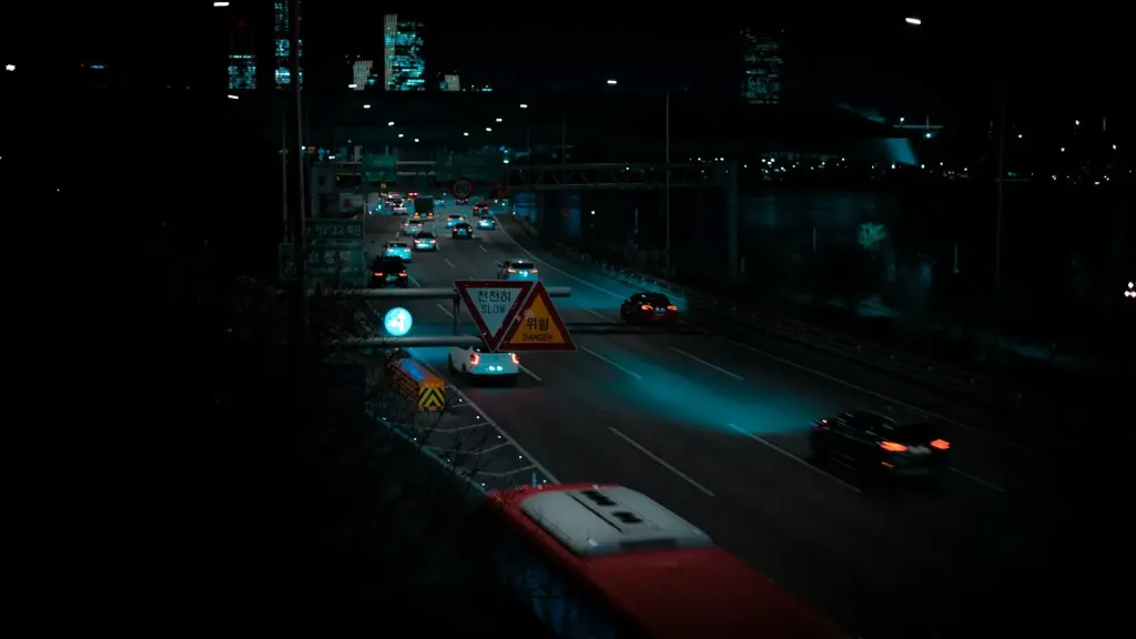 A Seoul road at night, tail lights running under an overpass.