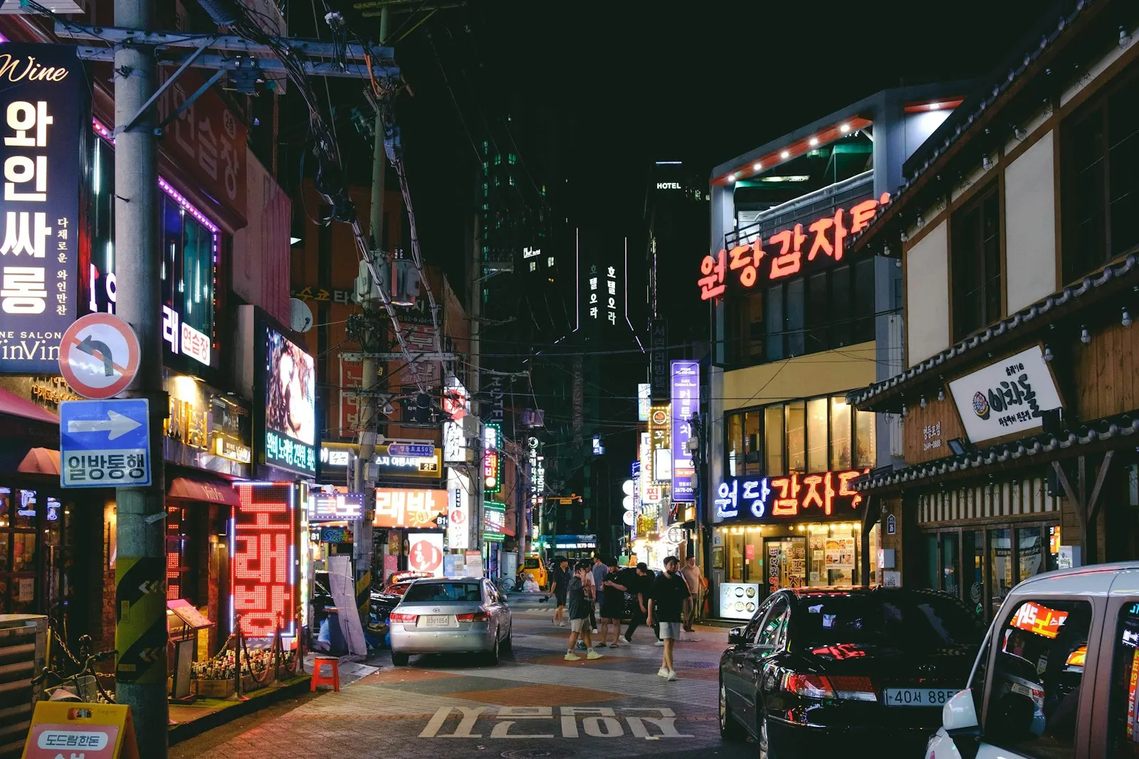 A Seoul street at night lined with neon signs