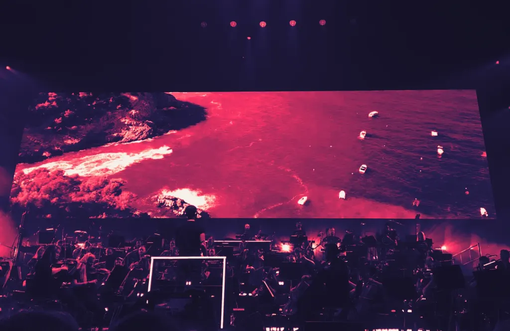 The Heritage Orchestra performing Ibiza Classics at Leeds Arena with Jules Buckley conducting and Pete Tong behind the orchestra
