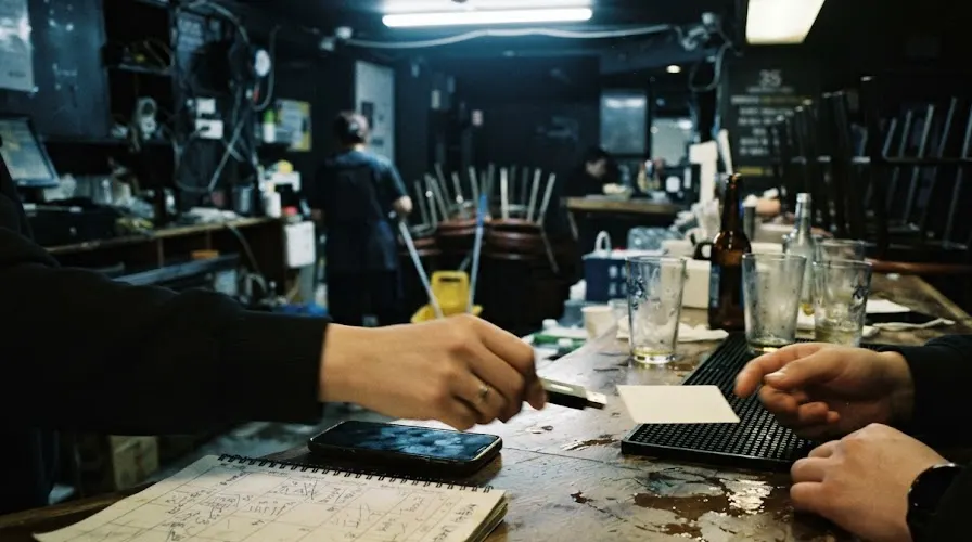A USB stick and a card passed across a Seoul club bar after closing, stools stacked behind