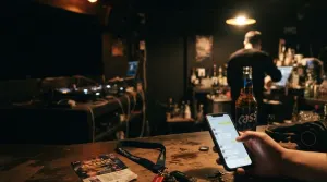 Checking booking messages on a phone at the bar of a Seoul club before opening