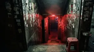 Red light spilling up a concrete stairwell into a basement club in Itaewon