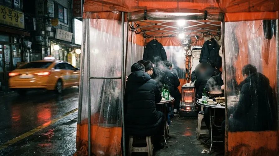 Office workers huddled inside an orange pojangmacha tent in Jongno on a winter night