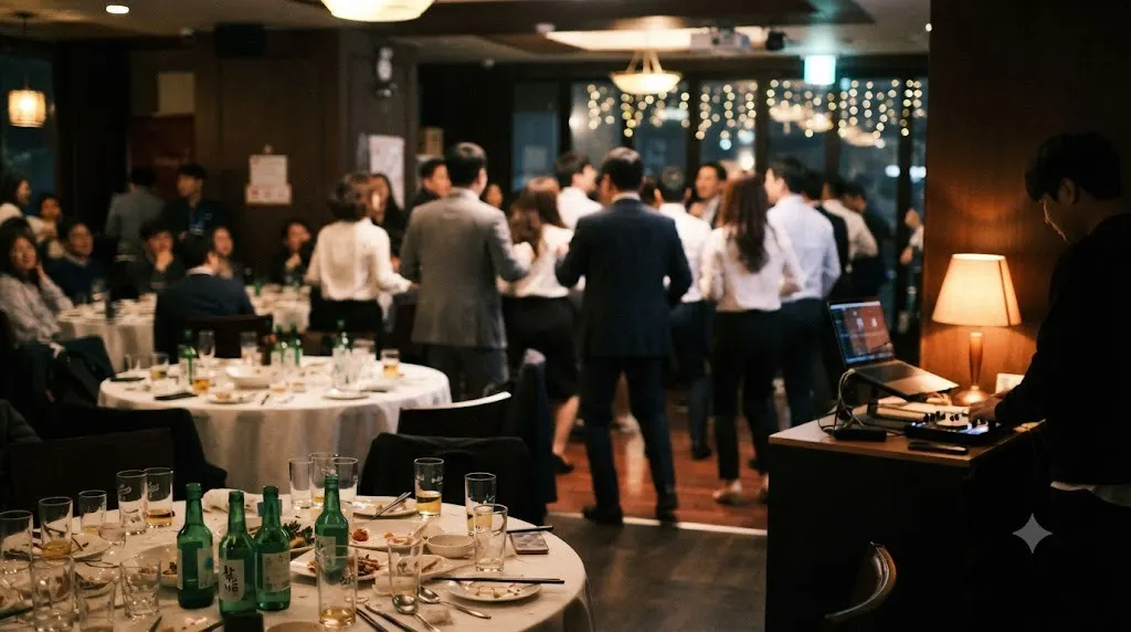 Colleagues dancing at a company year end party in a Seoul dining hall, with a DJ table at the side