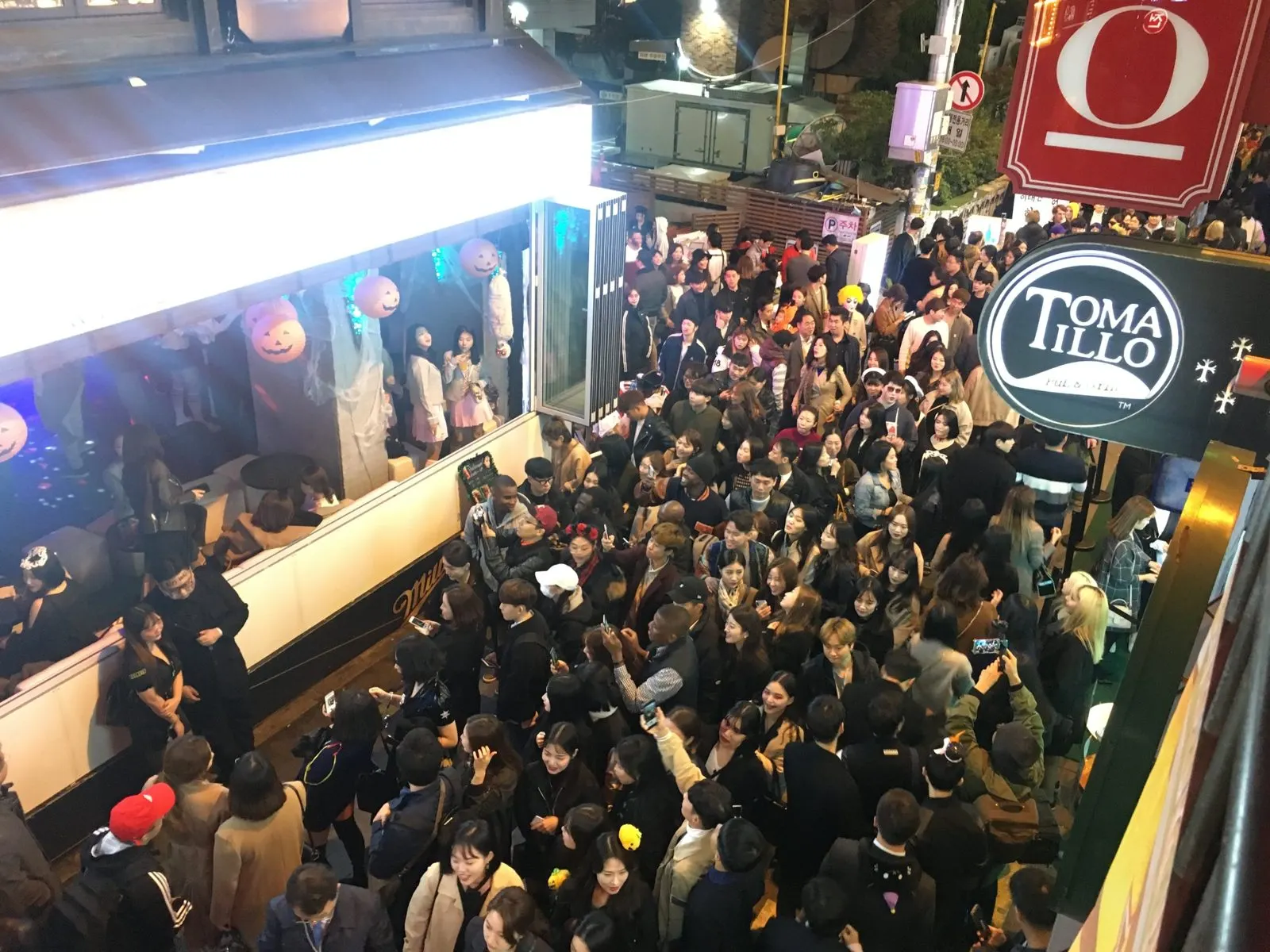 A costumed crowd outside Itaewon bars, seen from above