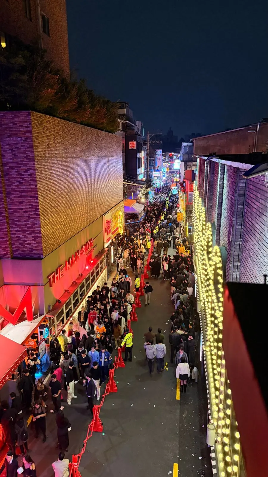 World Food Street in Itaewon last Halloween, split by red barriers with officers in yellow vests