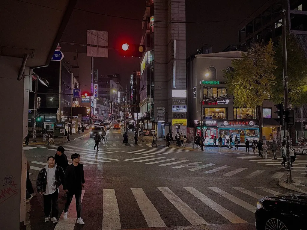 Pedestrians crossing a street in Itaewon at night