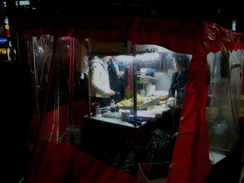 A red pojangmacha street food tent glowing at night in Seoul