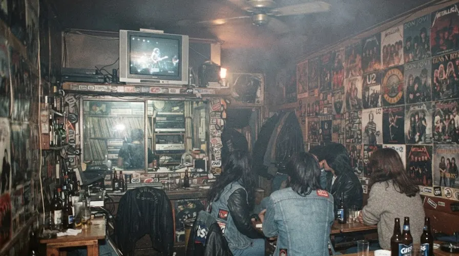 Students in denim at a smoky Sinchon rock cafe in the late 1980s, posters covering the walls